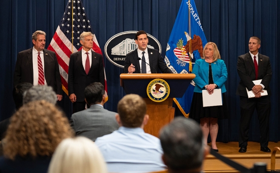 Matthew R. Galeotti delivers remarks from a podium at the Department of Justice. He is joined by Department of Justice and federal government officials.
